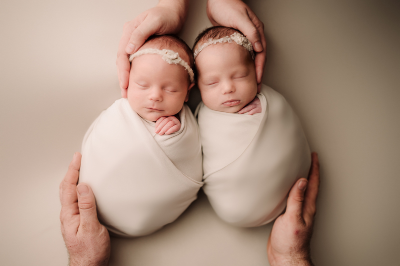 Newborn Photographer, Two twin baby girls lay swaddled and sleeping beside each other